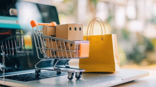 Shopping cart filled with product boxes and a shopping bag beside a laptop, highlighting e-commerce and online shopping convenience.