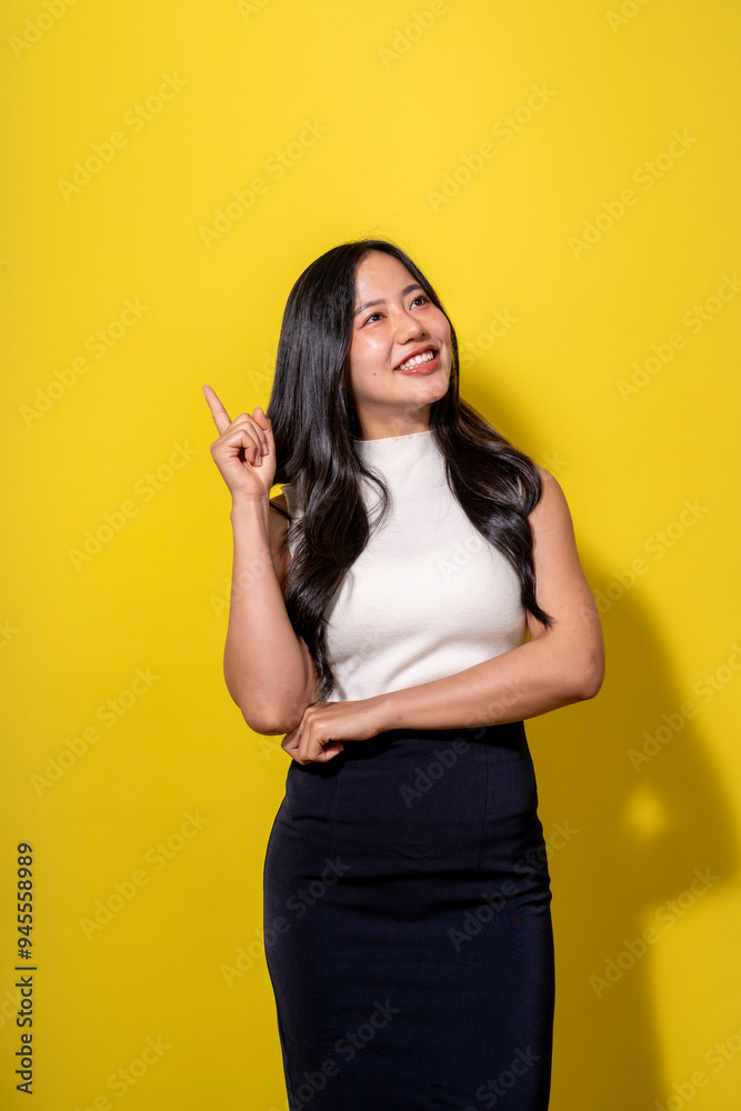 A woman with long black hair and a white shirt is pointing her finger up A woman with long black hair and a white shirt is pointing her finger up