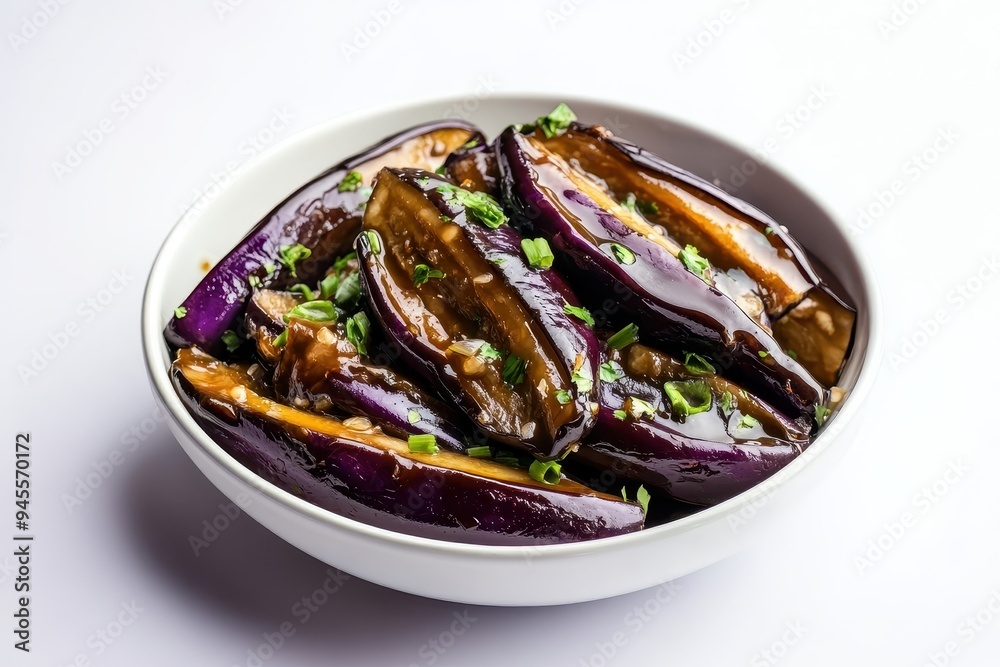 A bowl of cooked eggplant garnished with green onions. A bowl of cooked eggplant garnished with green onions.