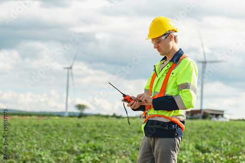 man in a yellow and orange safety vest is looking at a device