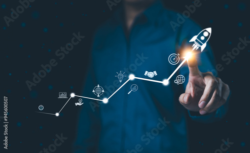 Startup business and investment concept. Businessman is touching the growing business graph. Planning and starting corporate business start up, Rocket icon soars with speed to hit the growth target.