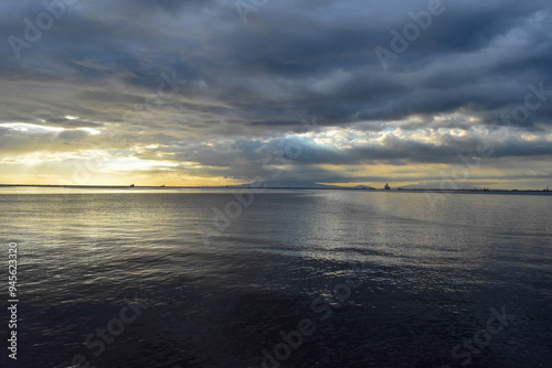 Calm sea meeting a cloudy sky at the horizon during sunset