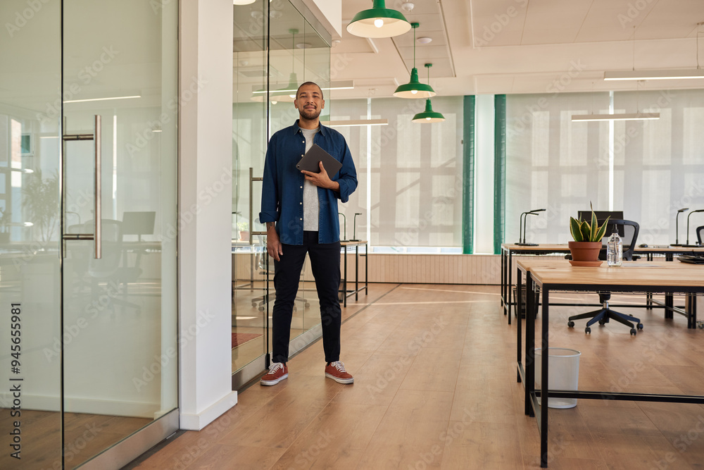 Smiling young businessman with a tablet standing in an office Smiling young businessman with a tablet standing in an office