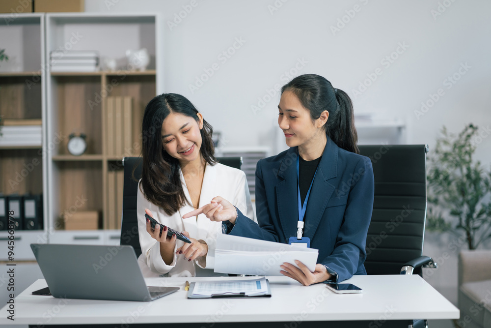 Two Young Asian businesswoman working on a project in the office or reviewing and discussing a business project. Two Young Asian businesswoman working on a project in the office or reviewing and discussing a business project.