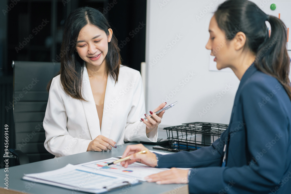 Two Young Asian businesswoman working on a project in the office or reviewing and discussing a business project. Two Young Asian businesswoman working on a project in the office or reviewing and discussing a business project.