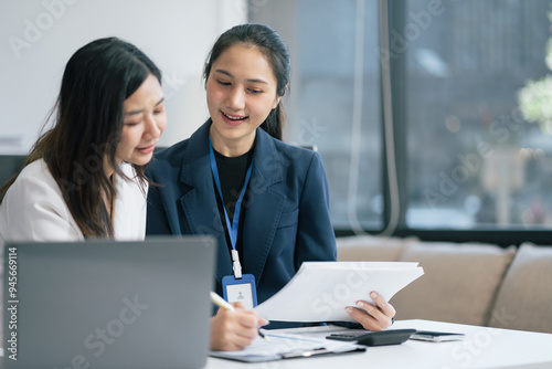 Two Young Asian businesswoman working on a project in the office or reviewing and discussing a business project.