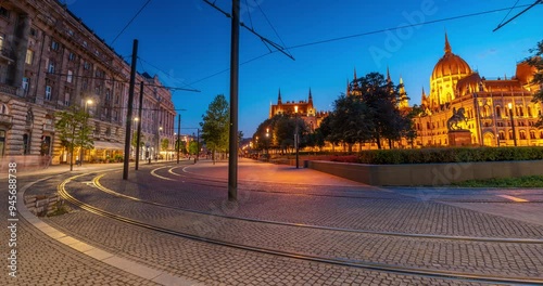 Budapest, Hungary: July 08, 2024: Tram traffic on Kossuth Lajos Square at twilight. Parliament building on the right. Time-lapse, slide transition.
