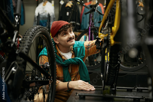 Hipster man selecting new mountain bike in shop