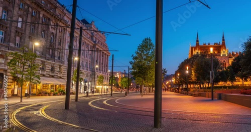 Budapest, Hungary: July 08, 2024: Tram traffic on Kossuth Lajos Square at twilight. Parliament building on the right. Time-lapse, zoom-out transition.