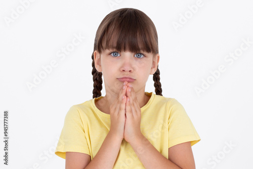 Cute kid putting his hands together as if begging for something, sadness feel.