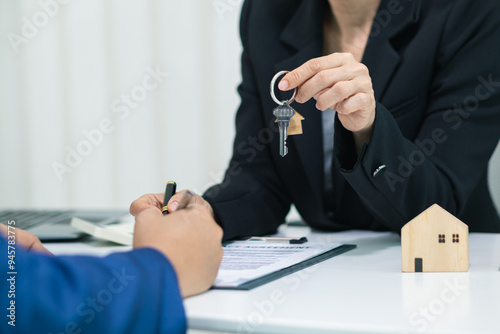 Tableau sur toile Real estate agent handing over house keys to customer after agreeing to sign sales contract and signing real estate handover contract to customer