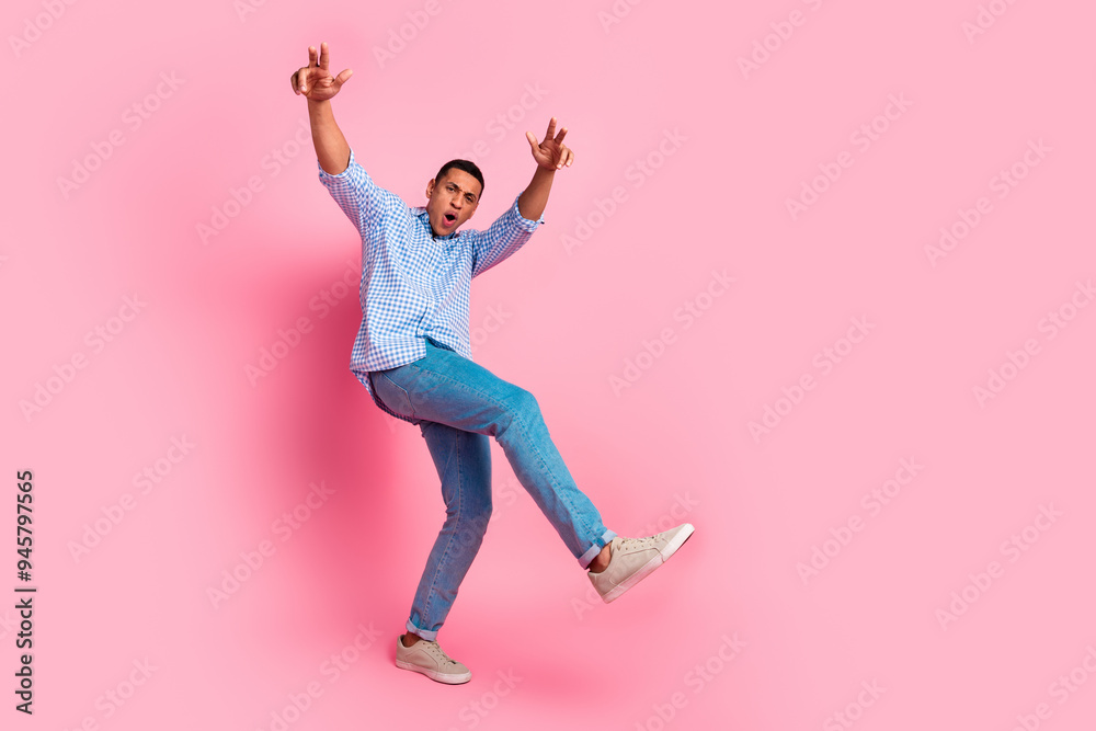 Full length photo of excited cool guy dressed checkered shirt dancing emtpy space isolated pink color background Full length photo of excited cool guy dressed checkered shirt dancing emtpy space isolated pink color background
