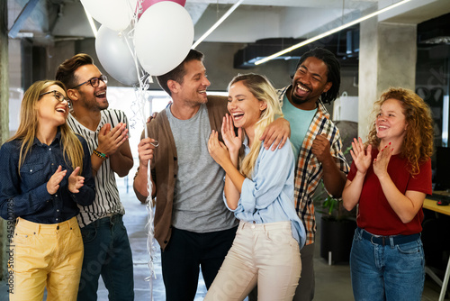 Friendly diverse employees congratulating businesswoman with business achievement
