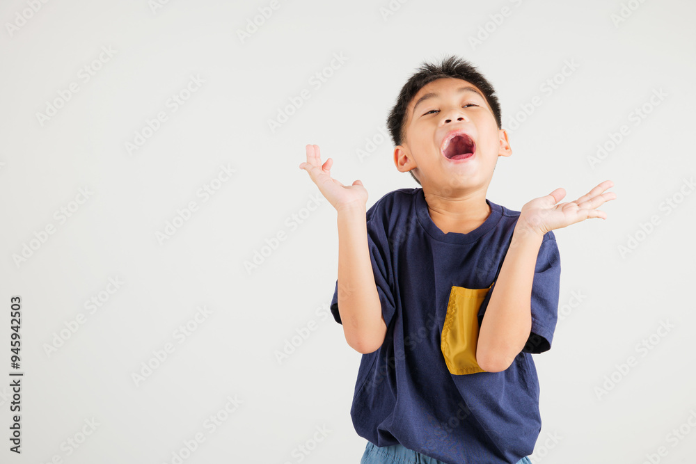 A jubilant kid boy raises her fists in celebration of her success, saying yes with excitement. Asian portrait of a happy young primary child in a studio shot on a white background, winning A jubilant kid boy raises her fists in celebration of her success, saying yes with excitement. Asian portrait of a happy young primary child in a studio shot on a white background, winning