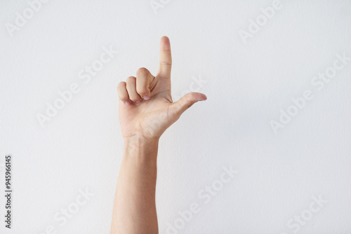 Hand, pointing and person with direction in studio for vote, opinion or presentation of mockup space. Arrow, sign and arm of model with showing gesture for letter with spelling by white background.