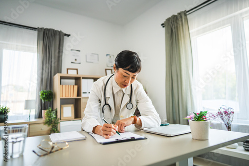 one woman mature japanese doctor work examine clipboard 