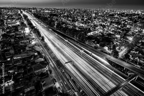 Illuminated Highway at Night with Bright Streetlights Casting Glows on Asphalt Roads, Creating a Serene Nighttime Scene of Road Illumination and Urban Lighting