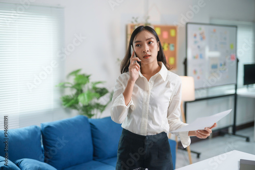 Businesswoman is having a phone call and receiving bad news while reading documents in her office