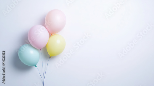 a small cluster of pastel-colored balloons gently tied against a white background, with copy space for text