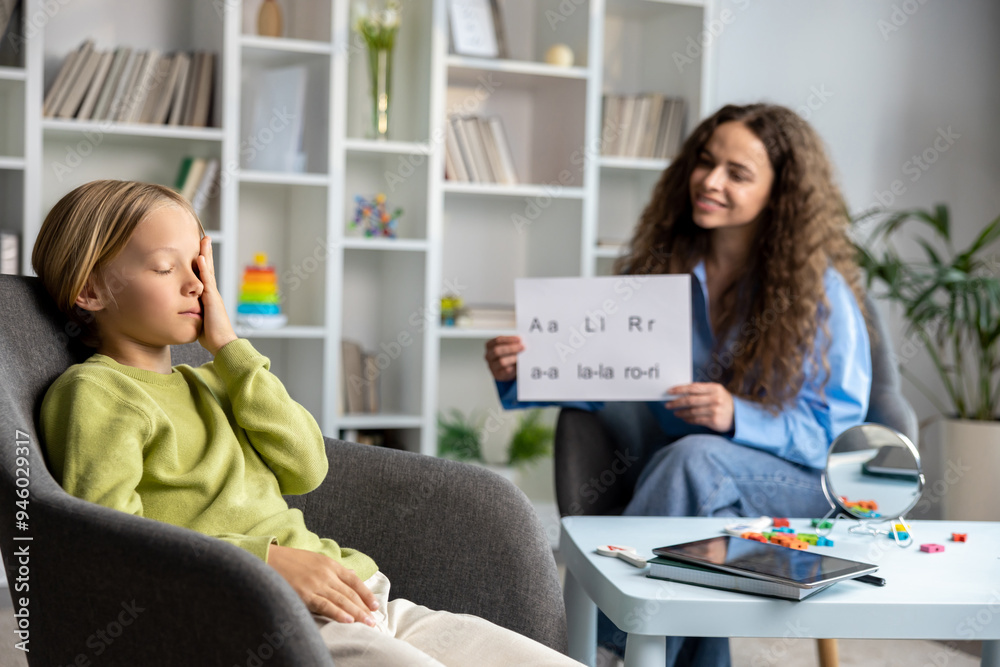 Blonde boy looking upset and unhappy during speech therapy Blonde boy looking upset and unhappy during speech therapy