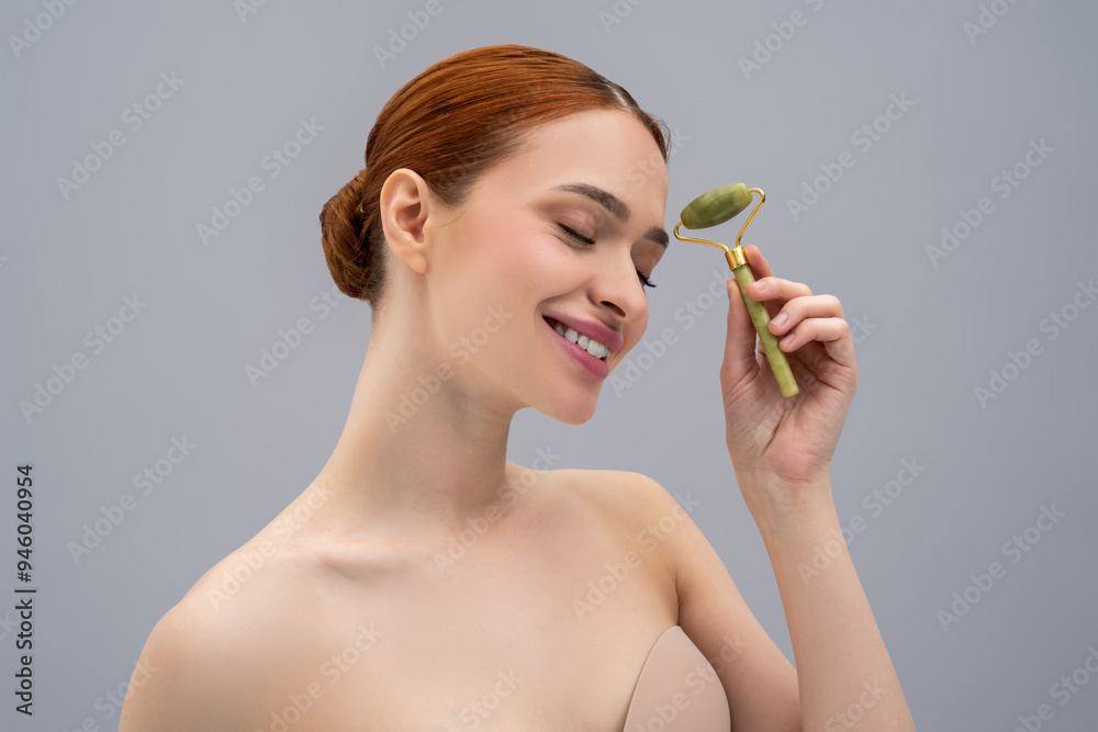 Cute ginger woman with a face roller in hands Cute ginger woman with a face roller in hands