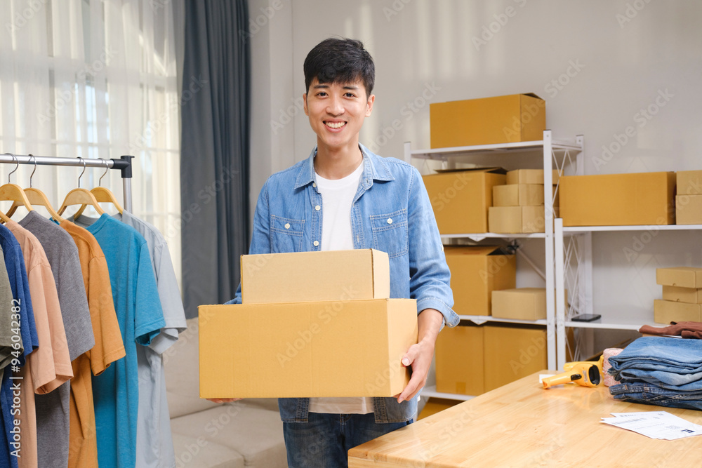 Portrait of a confident young online entrepreneur working from his home office, surrounded by clothing products and shipping boxes. Portrait of a confident young online entrepreneur working from his home office, surrounded by clothing products and shipping boxes.
