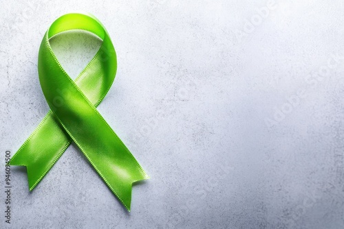 Green Awareness Ribbon on White Textured Background photo