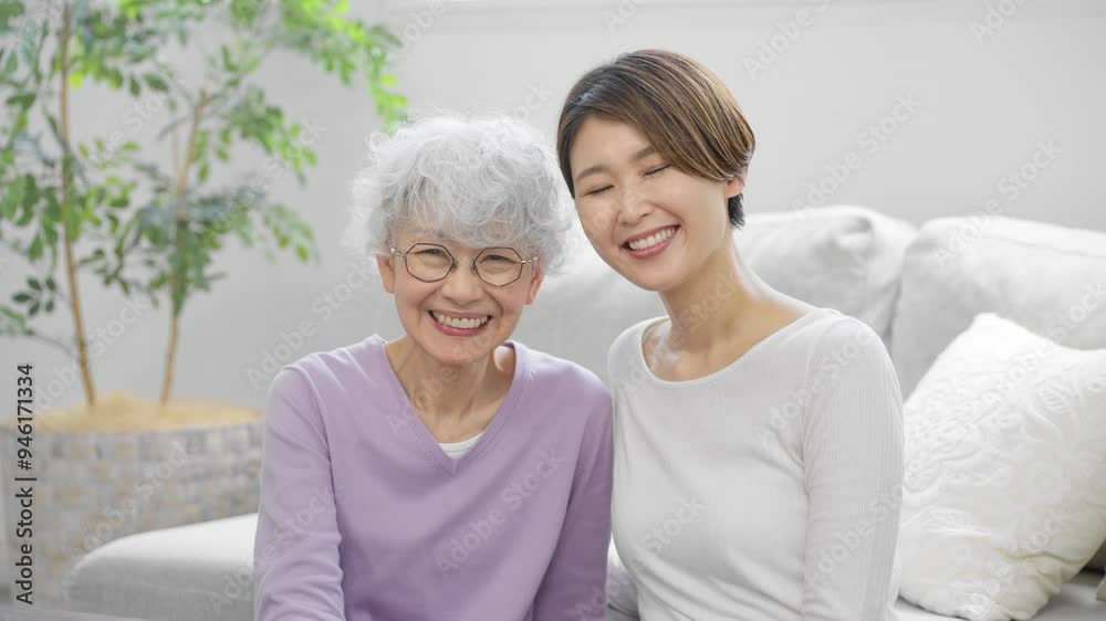 並んで座る若い女性とシニア女性 並んで座る若い女性とシニア女性
