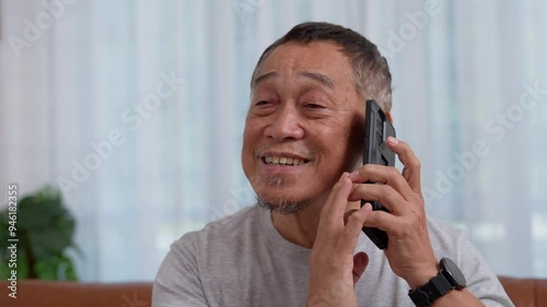 Blind Asian elderly men use digital assistant get ease of access functions on smartphone, Voice typing on phone. Person visually impaired and eye disease in the elderly Concept, Accessibility phone.