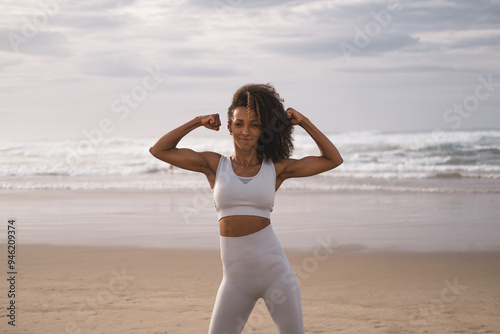 Outdoor portrait of motivated black female fit woman at the beach. Fitness lifestyle success and motivation concept.