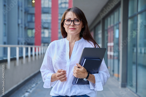 Outdoor portrait of middle aged businesswoman, modern urban city background