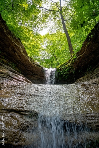A small waterfall in a deep ravine in a forest