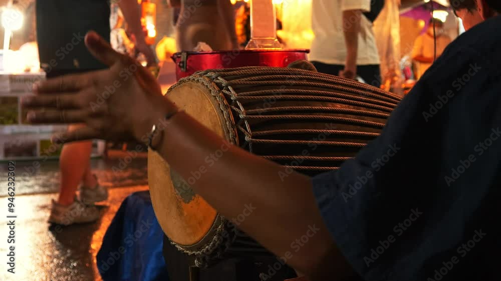 Street musician playing a tabla - a traditional Indian drum, with fingers and palms, at Night Market, Chiang Mai, Thailand