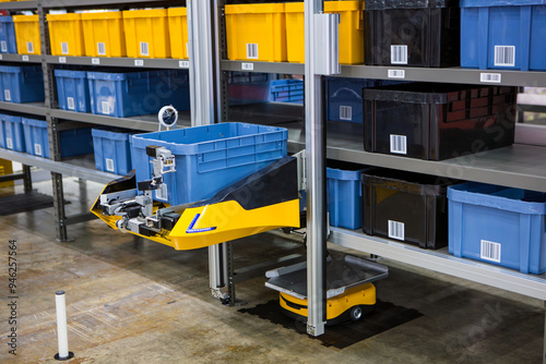 Autonomous robot picking materials from multi-layer rack in modern industrial warehouse.