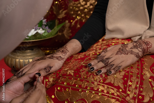 The process of painting henna on the bride's hands. There are many different names for henna tattoo across the globe, such as mehndi, inai, hina, camphire, and hena