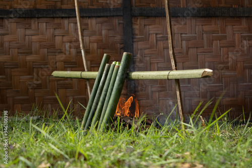 The process of making lemang, a food that is quite well-known in Malaysia and Indonesia. A man is making lemang, a food made from sticky rice that is put into bamboo lined with banana leaves