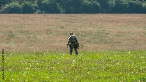 British army soldier tabbing with 25Kg bergen and rifle across open countryside, Wiltshire UK photo