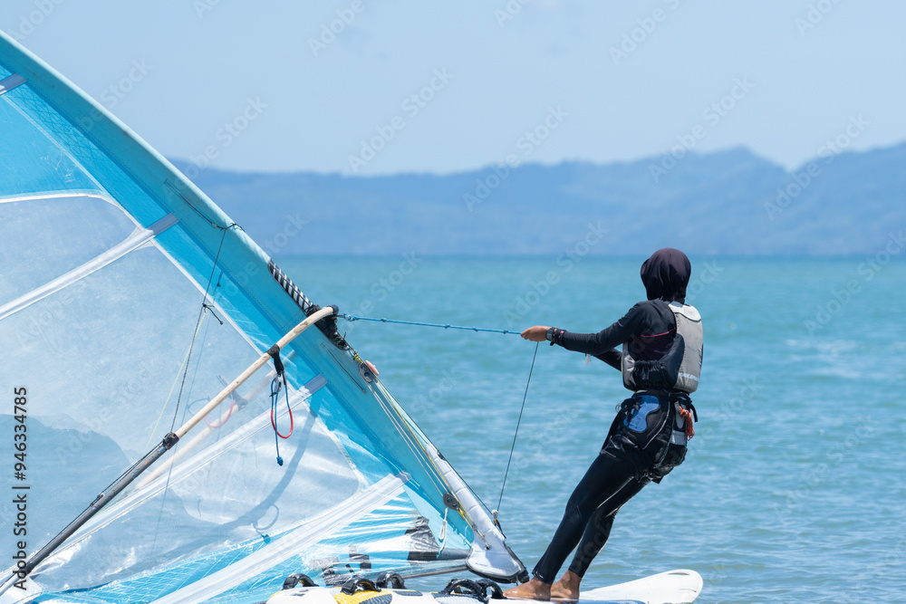Naklejka premium A windsurfer plays with the wind and ocean waves