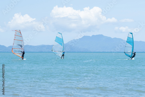 Windsurfers plays with the wind and ocean waves photo