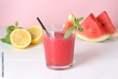 Tasty watermelon drink in glass, mint and fresh fruits on white wooden table