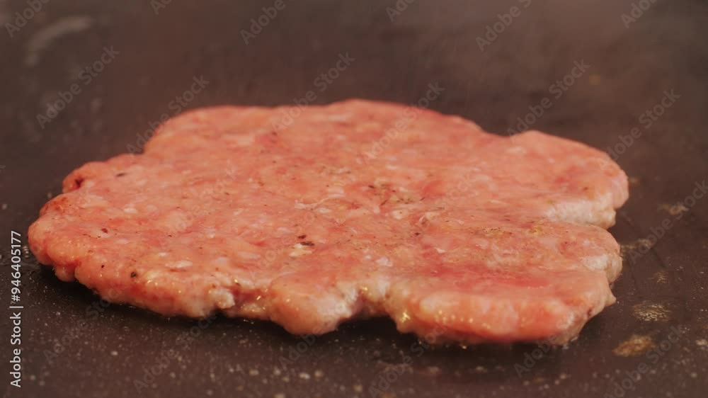 Cooking American fat smash burger on grill close-up. Beef or pork cutlet smashing by burger press. The chef in kitchen of the restaurant making cutlets for burgers - smash Cooking American fat smash burger on grill close-up. Beef or pork cutlet smashing by burger press. The chef in kitchen of the restaurant making cutlets for burgers - smash