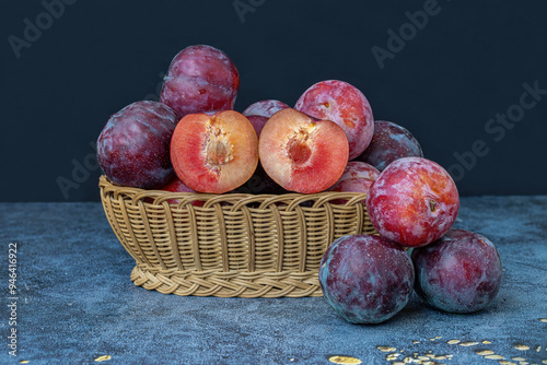 Red Angelica plums in a wicker basket on the table
