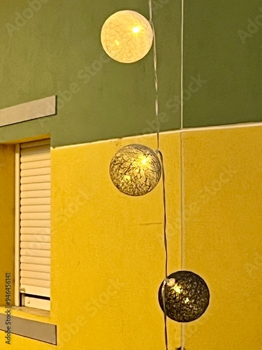 Decorative hanging balls in front of bright building and window