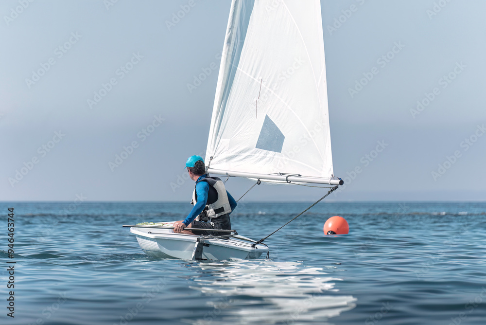 Naklejka premium Sportsman steering dinghy sailing boat on calm sea