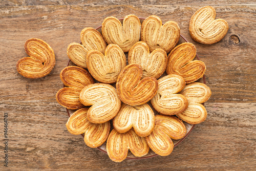 French Palmier cookies for tasty snack over wooden background. Heart shaped cookies.