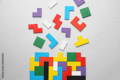 Colorful wooden puzzle pieces on light grey background, top view