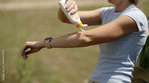 Woman applying sunscreen sun protection outdoors on sunny day