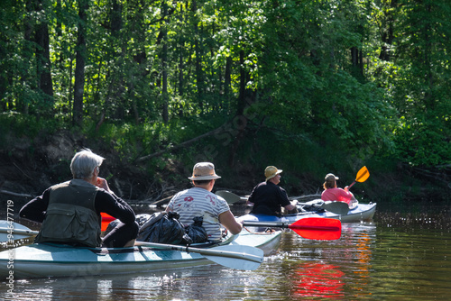 Group kayak trip for seigneur and senora . An elderly couple And adult rowing boat on the river, a water hike, a summer adventure. Age-related sports, mental youth and health, tourism, active old age photo