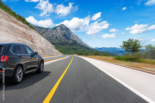 Obraz na płótnie The car is driving along the highway surrounded by picturesque nature. w salonie