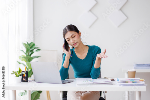 Cheerful business Asian woman freelancer making telephone call share good news about project working in office workplace, business finance concept. 